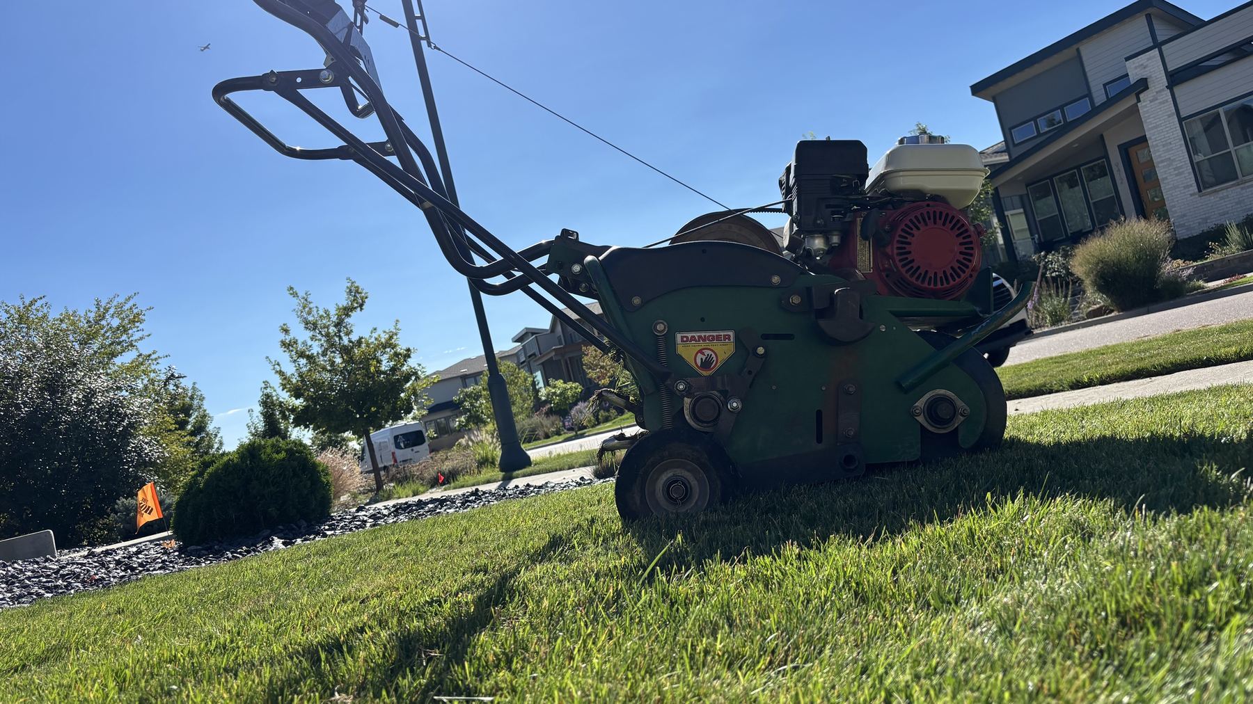 Core aerator parked on a green lawn in Lakewood, Colorado